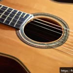기타 줄 감는 방법 - A detailed close-up of a classical guitar neck and body being carefully cleaned with a soft cloth an...